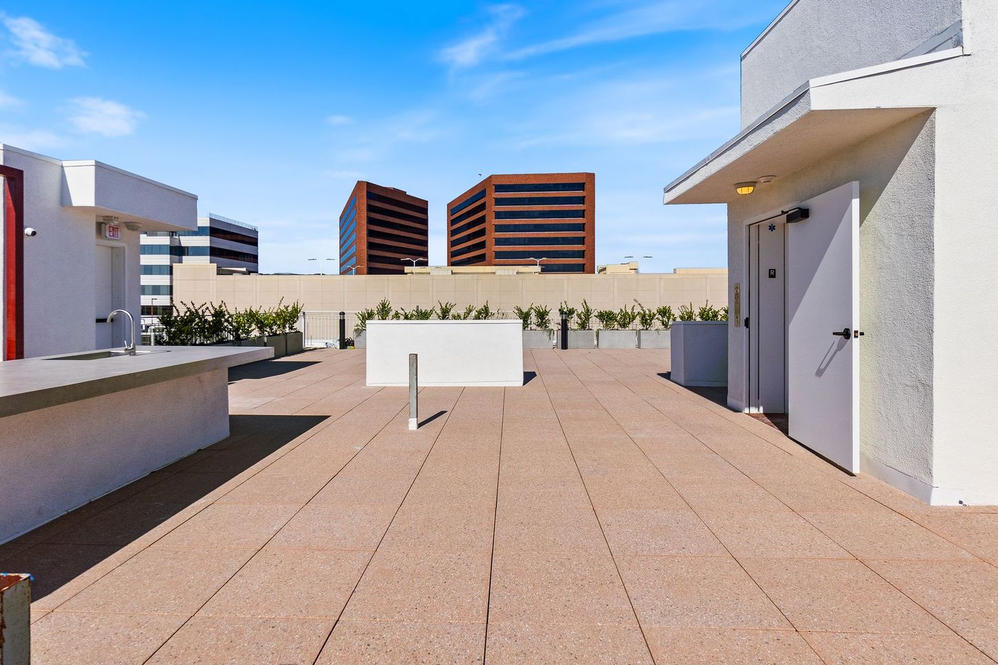 A rooftop deck with a few buildings in the background