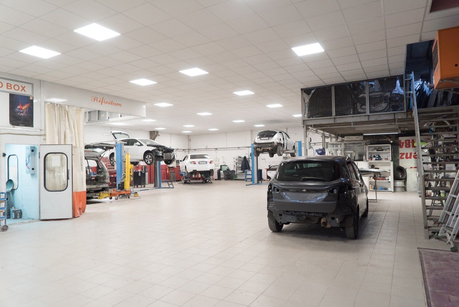 Un'auto è parcheggiata nel mezzo di un grande garage.