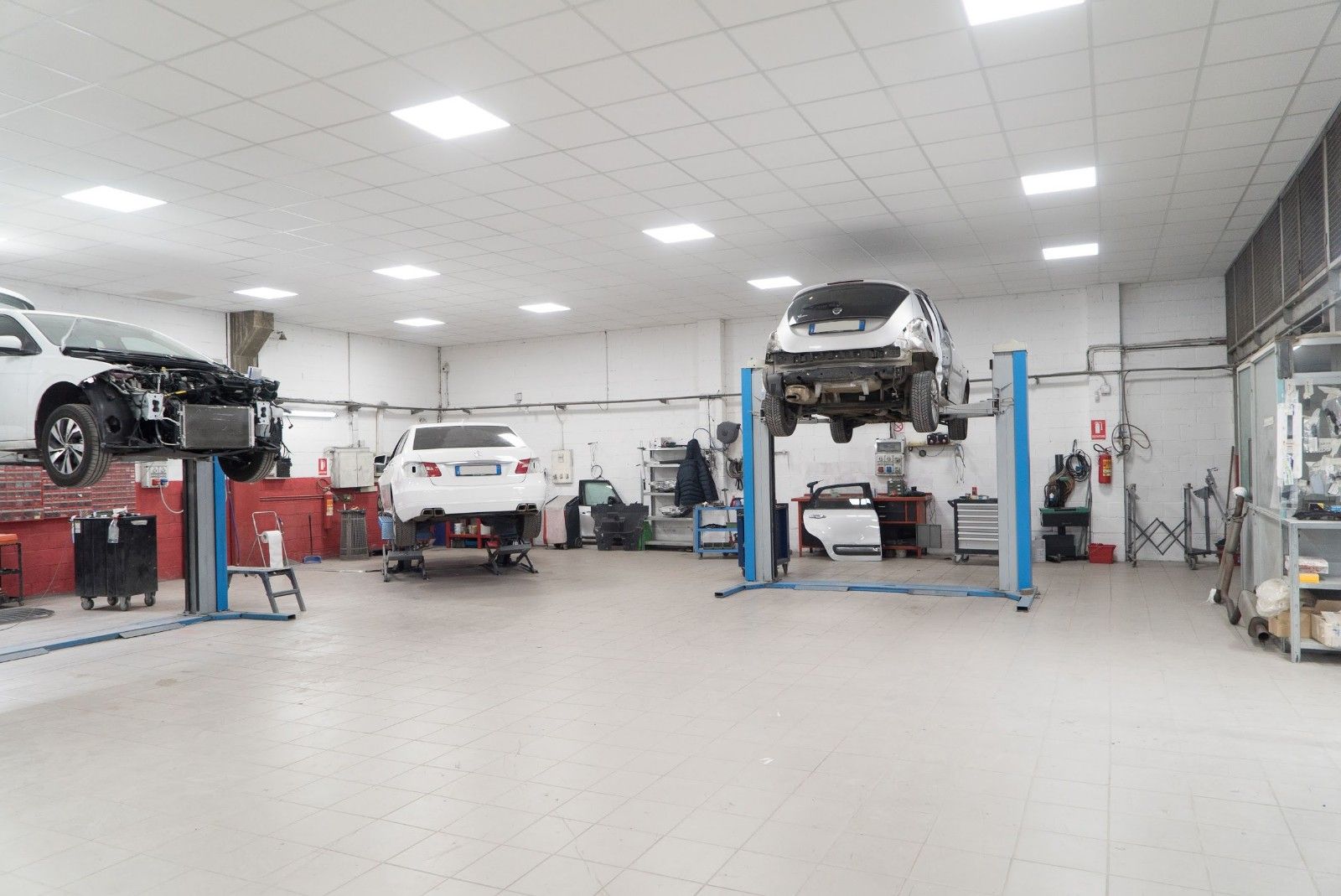 Un'auto è parcheggiata su un ponte sollevatore in un garage.