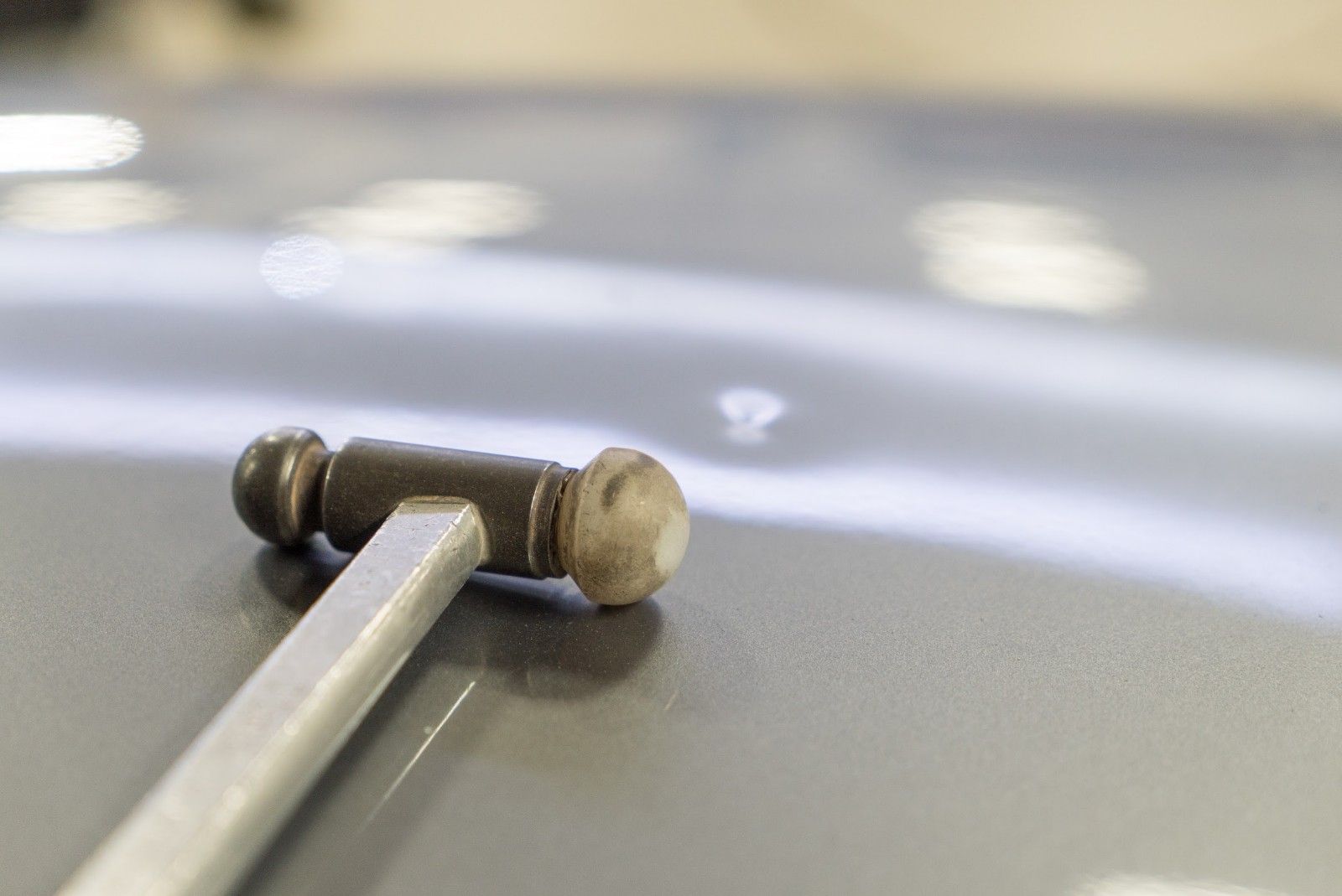 Un martello è appoggiato sul cofano di un'auto.