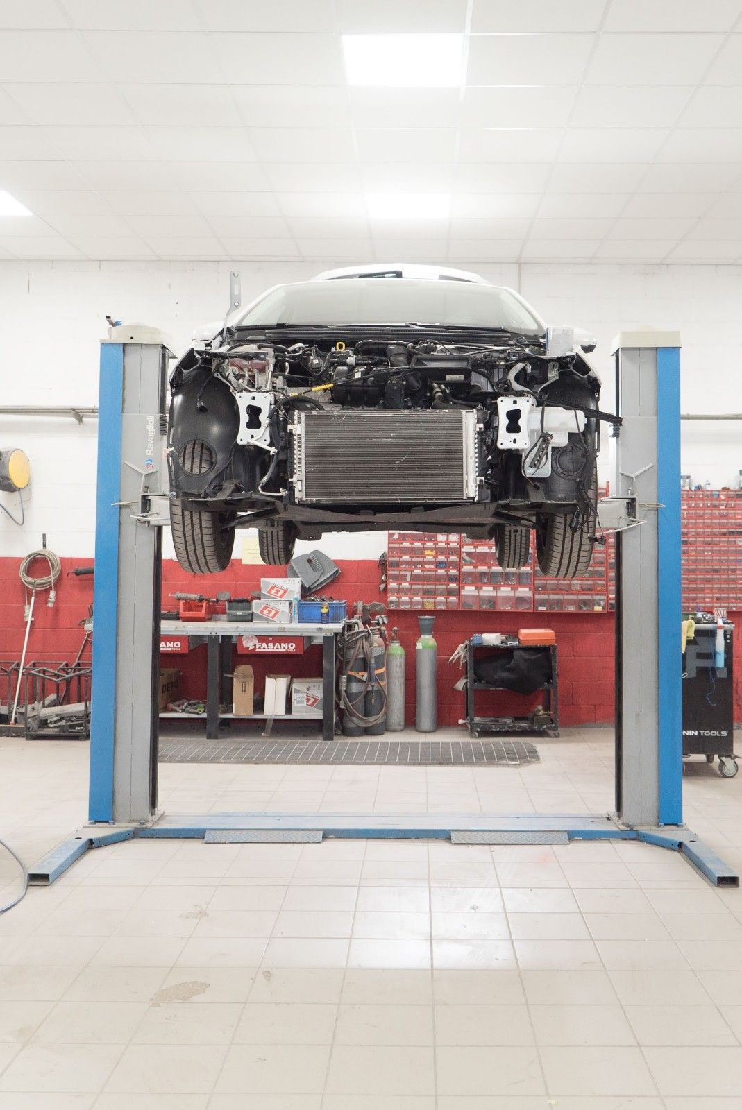 Un'auto è parcheggiata su un ponte sollevatore in un garage.
