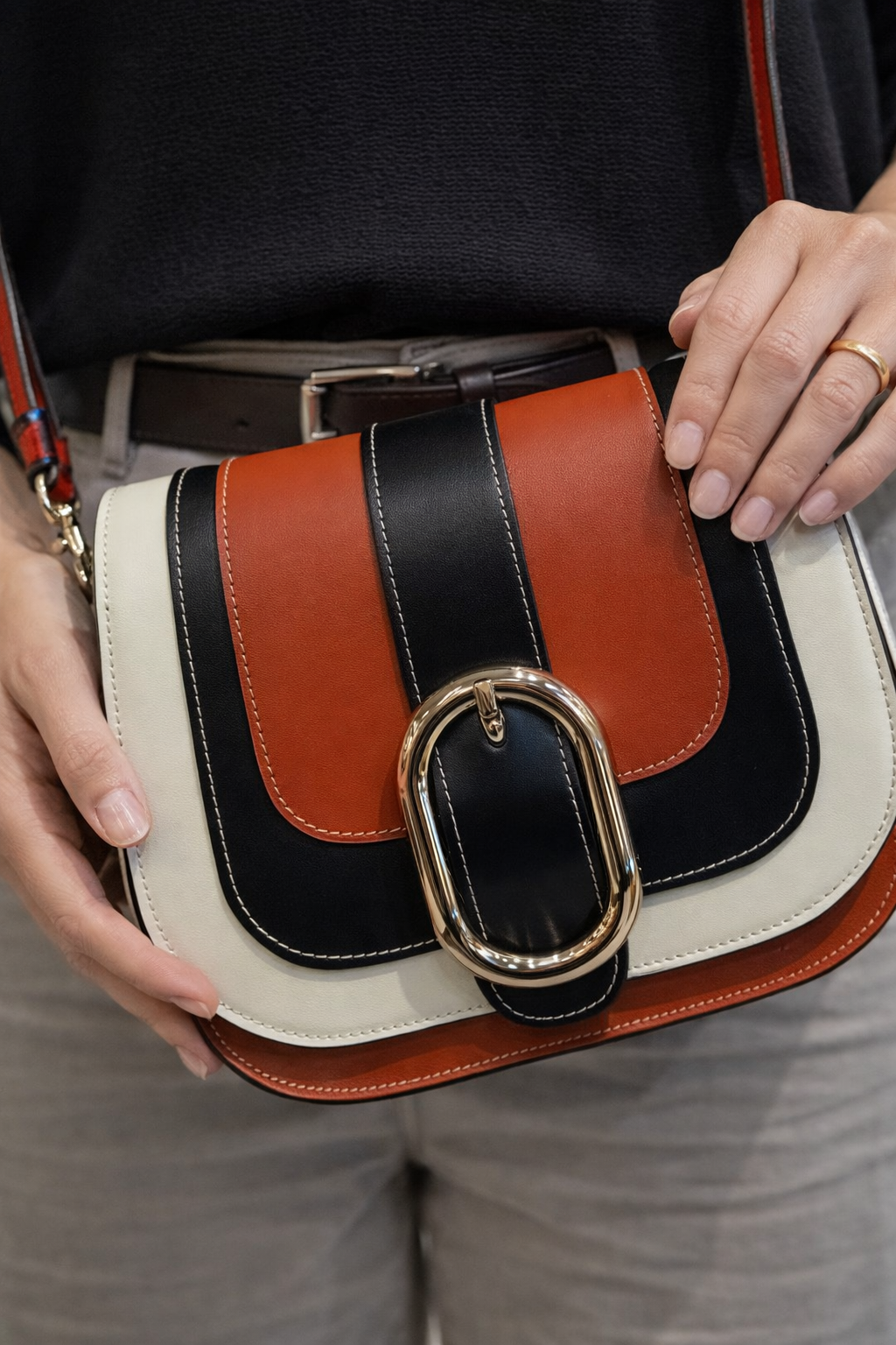 Uomo con giacca di pelle marrone, con cerniera, mani in tasca, in piedi in un negozio.