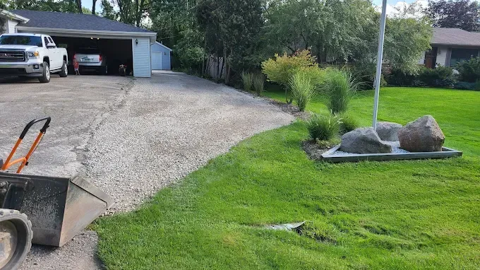 A truck is parked in a driveway next to a lush green lawn.