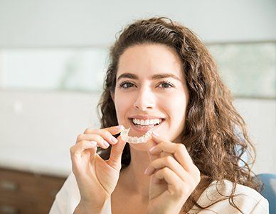 Patient Holding Orthodontic Retainers — Empire, MI — Empire Family Dental