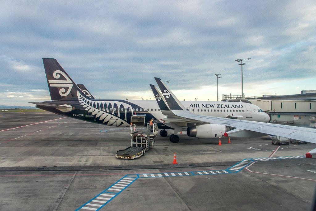 Two airplanes are parked on the tarmac at an airport