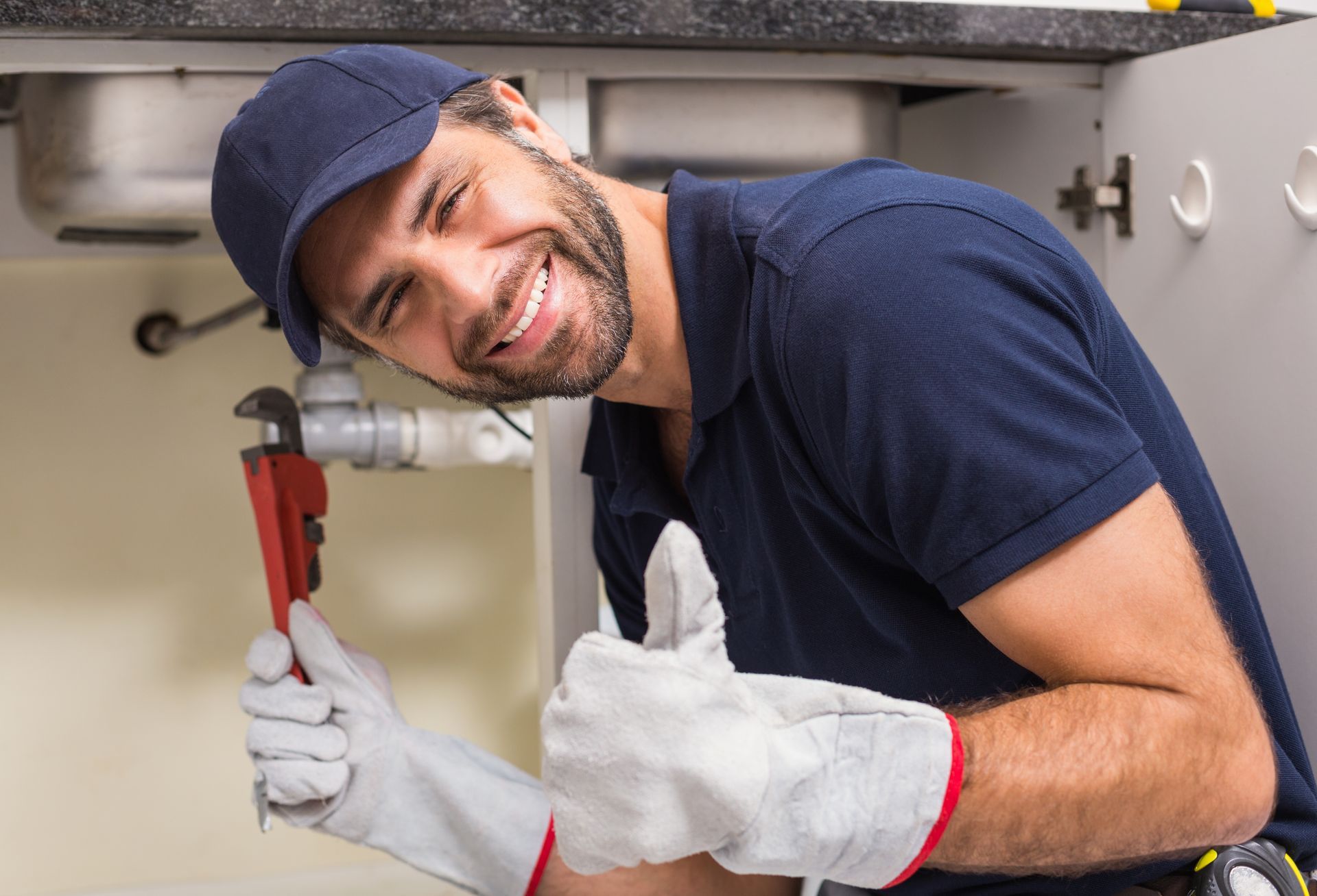plumber-smiling-camera-fixing-sink