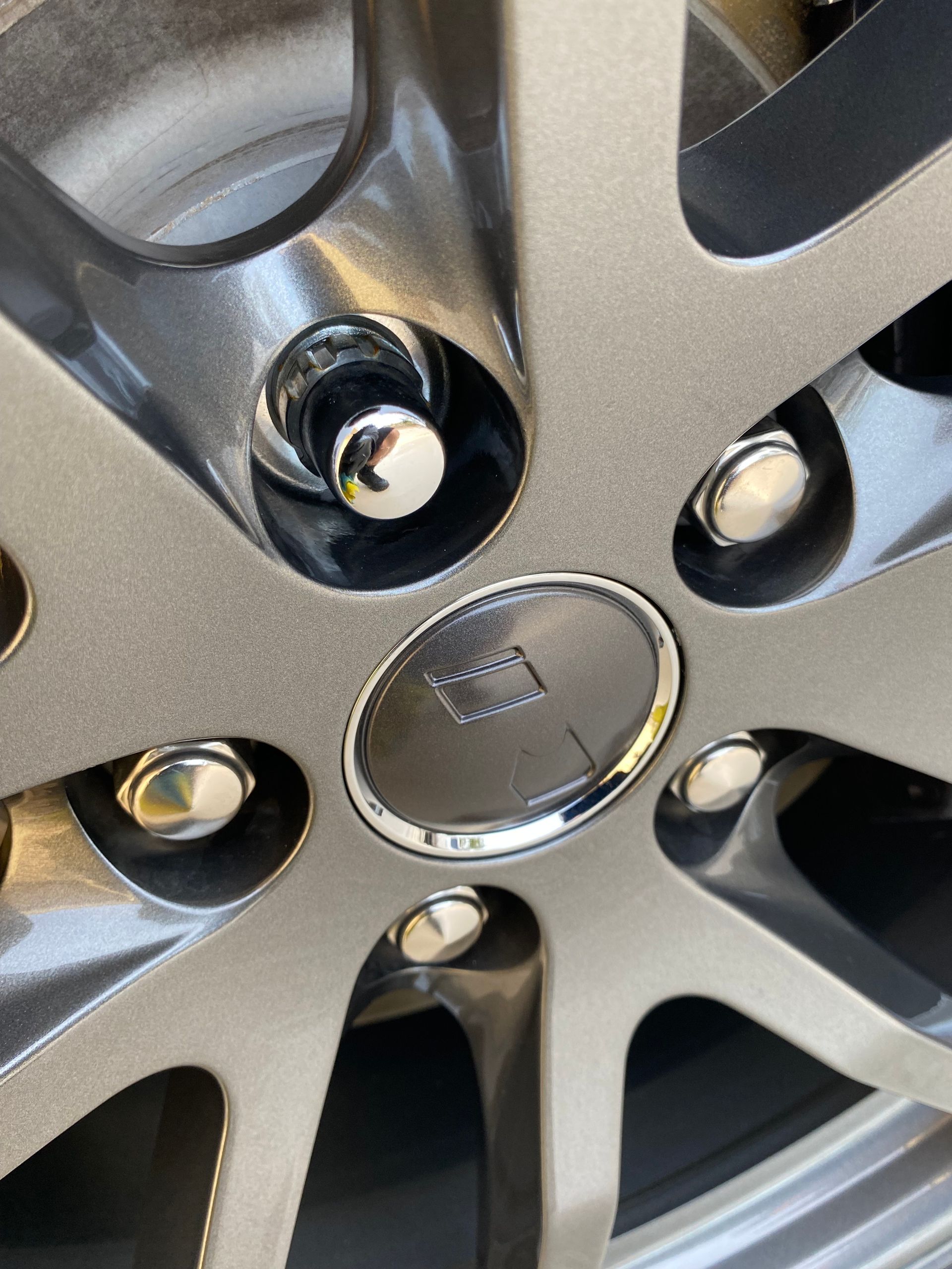 A close up of a car wheel with nuts on it