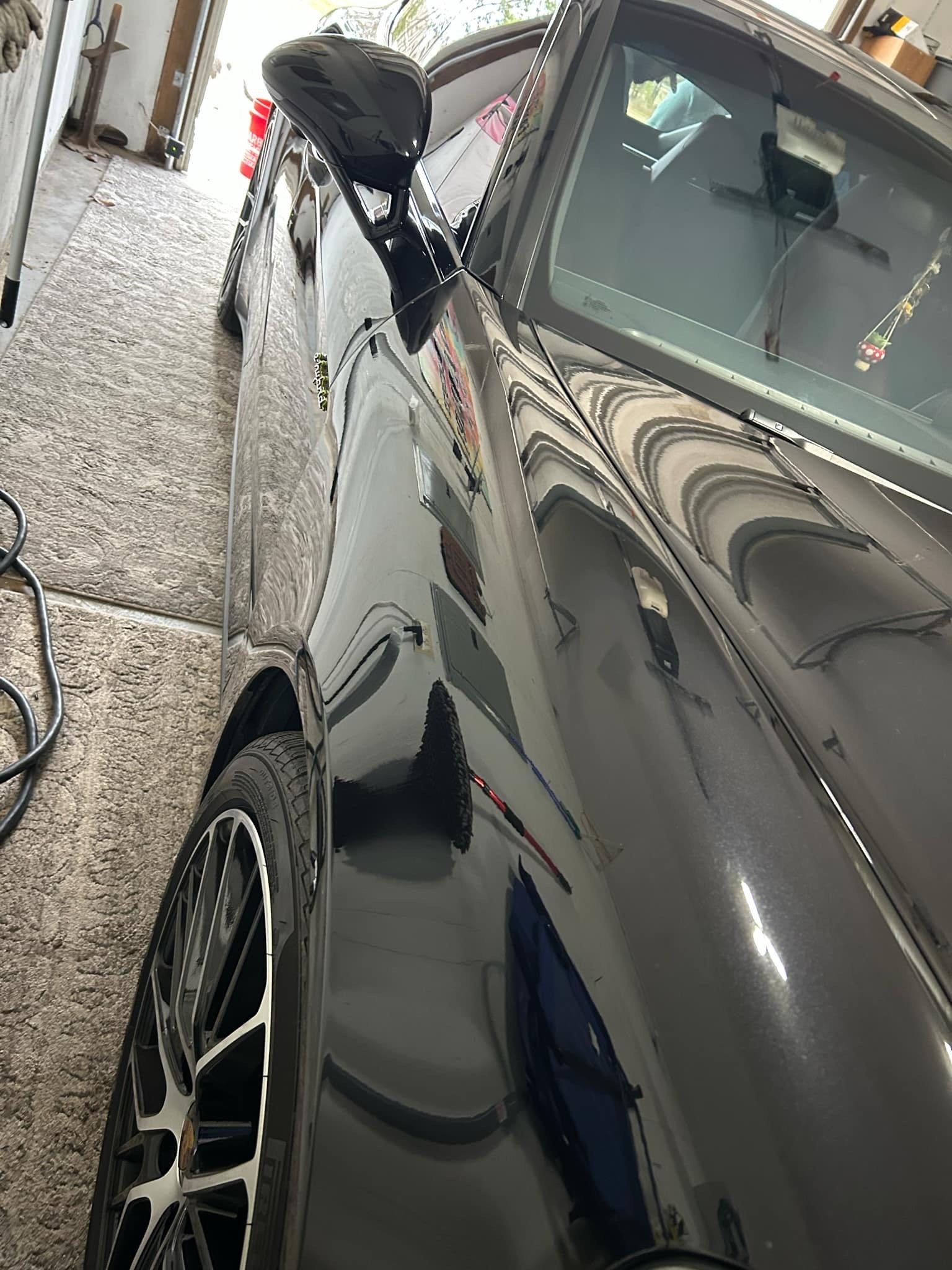 A black car is parked in a garage.