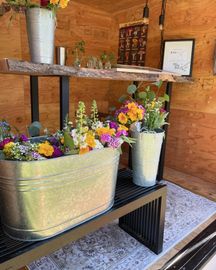 A metal tub filled with flowers is sitting on a table.