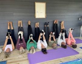 A group of women are laying on their stomachs on yoga mats.