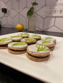 A white plate topped with a bunch of cookies with green frosting