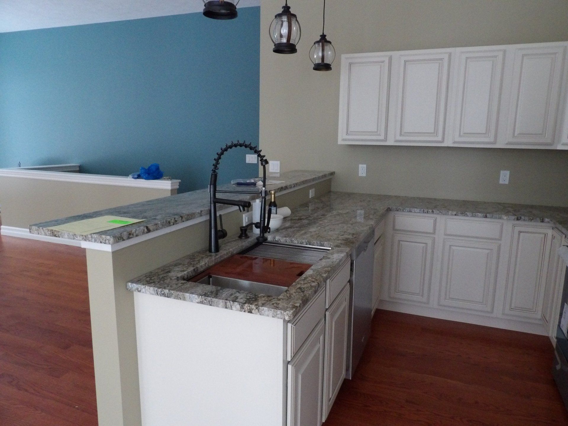 A kitchen with granite counter tops and white cabinets