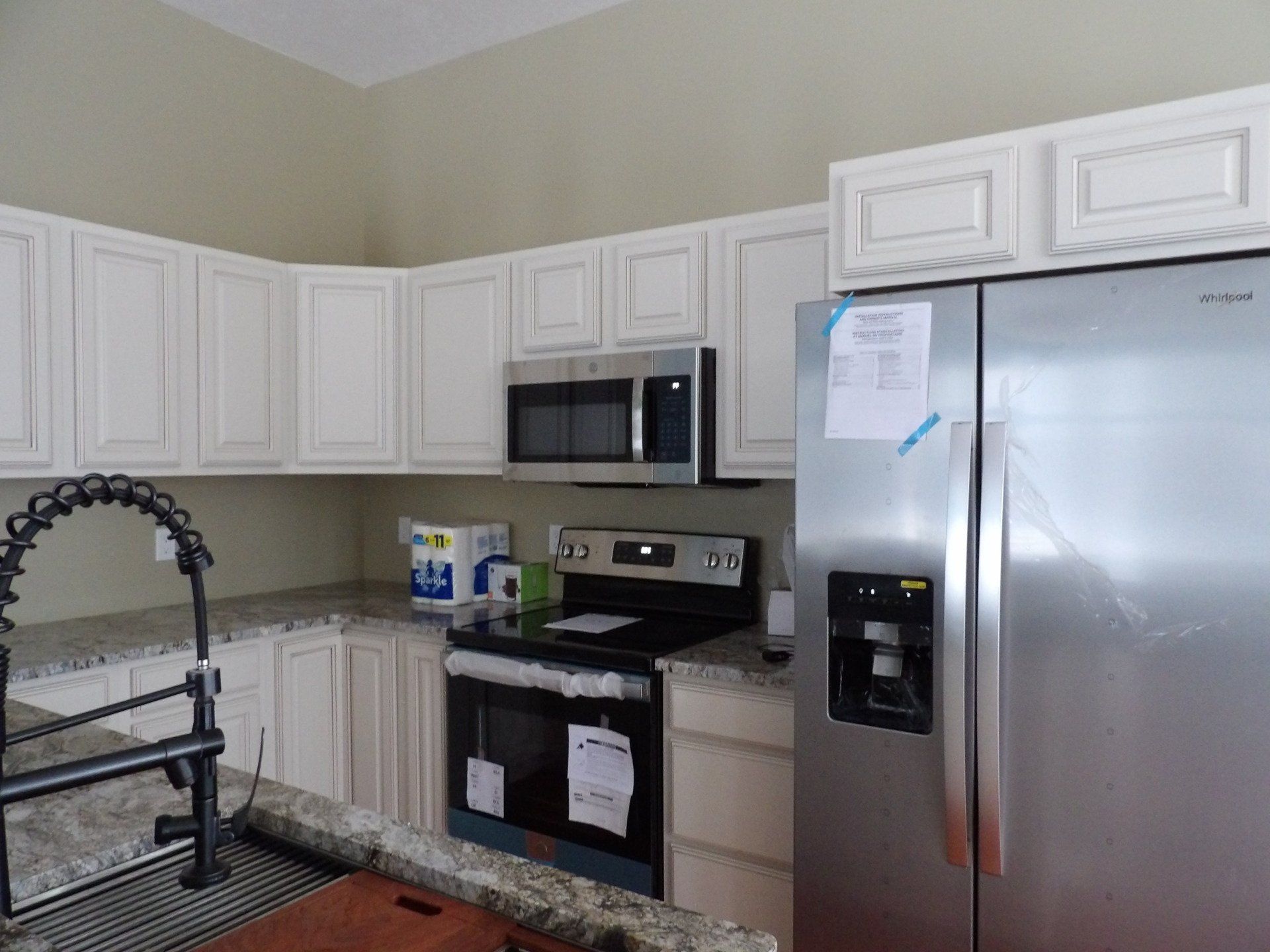 A kitchen with stainless steel appliances and white cabinets