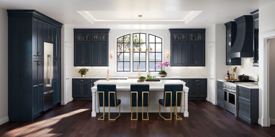 A kitchen with black cabinets , white counter tops , and a large island.