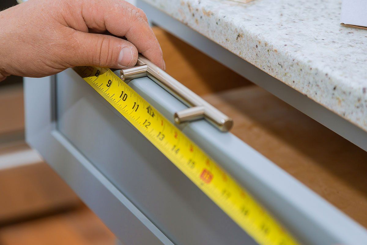 measuring to see where to put holes to install drawer handles