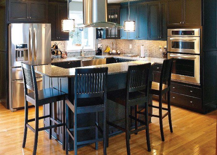 A kitchen with black cabinets and stainless steel appliances