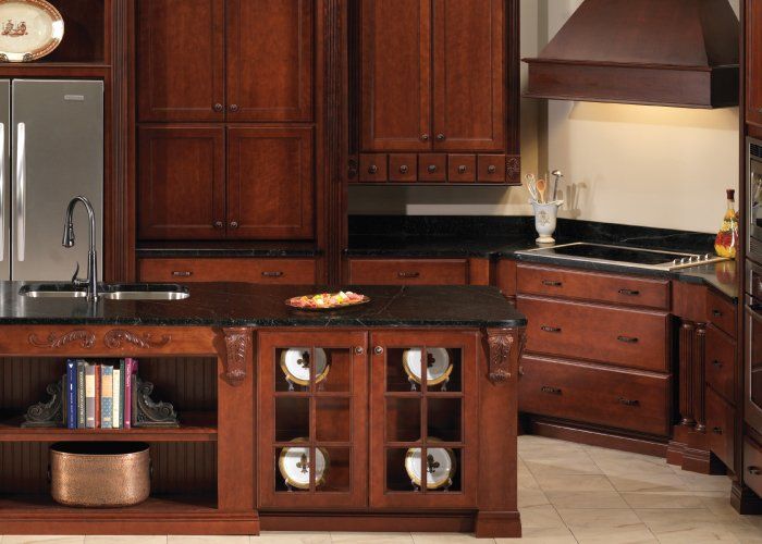 A kitchen with wooden cabinets and a black counter top