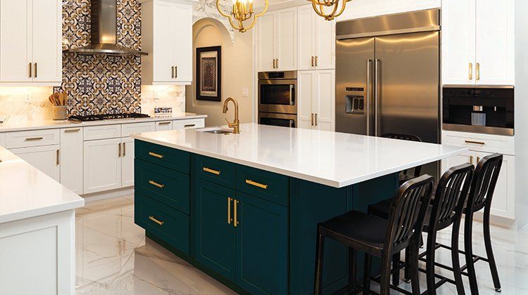 A kitchen with white cabinets , stainless steel appliances , and a large island.