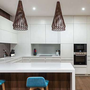 A kitchen with white cabinets and wooden stools
