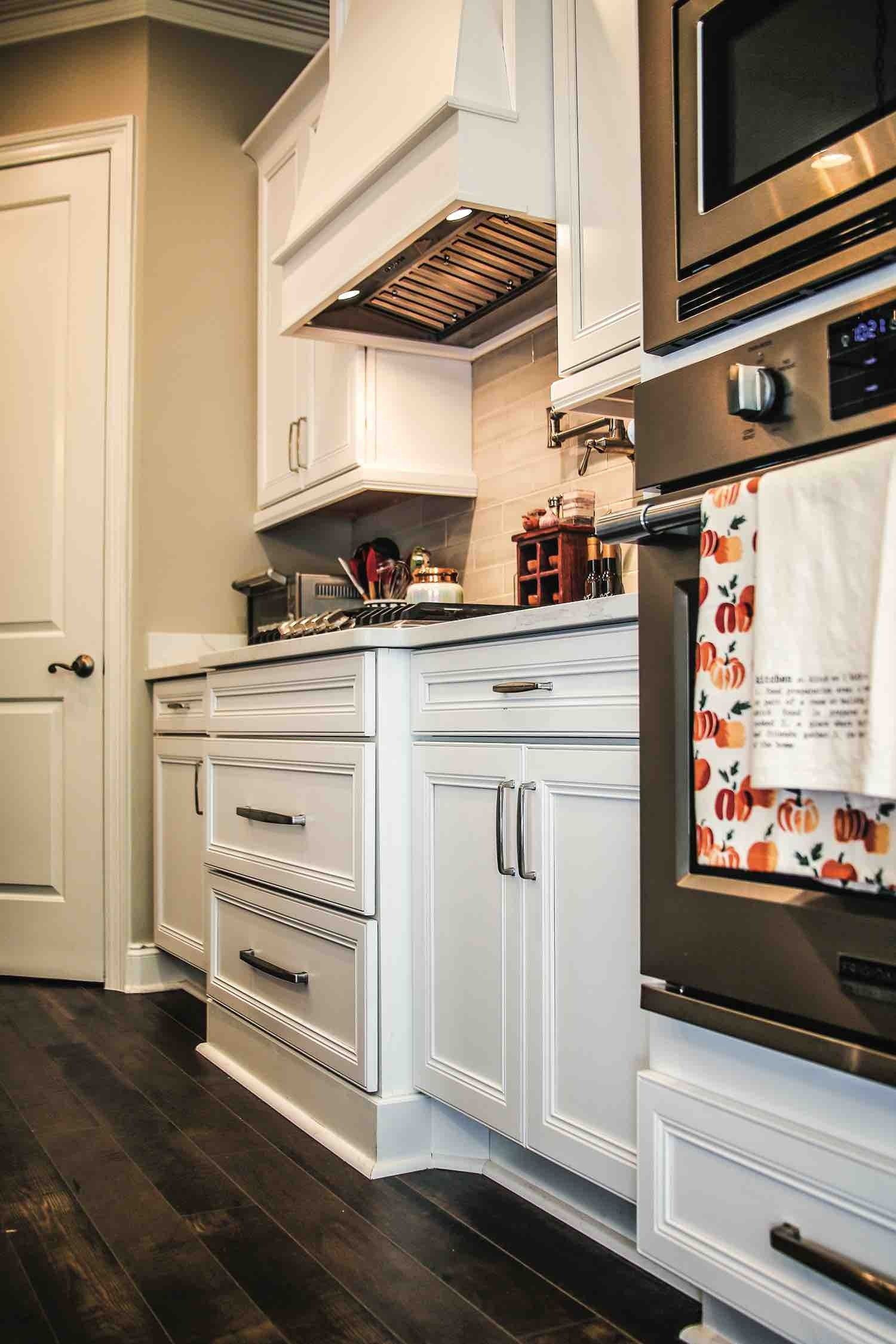 A kitchen with white cabinets and stainless steel appliances.