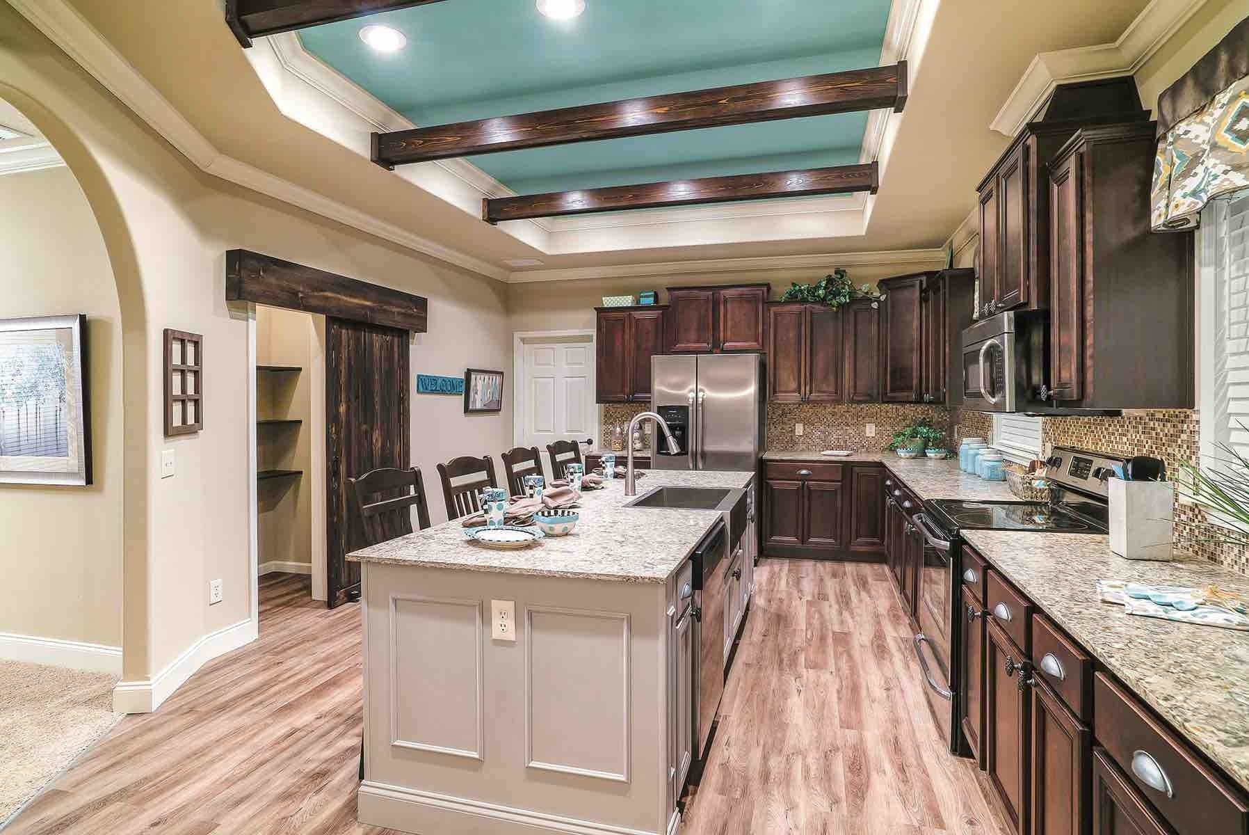 A kitchen with stainless steel appliances , granite counter tops , and a large island.