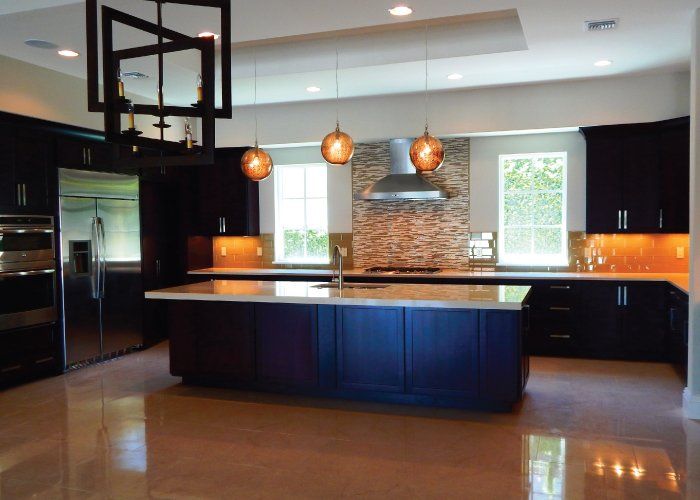 A kitchen with black cabinets and a large island