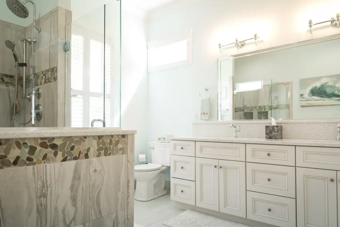 A bathroom with two sinks , a toilet , and a shower.