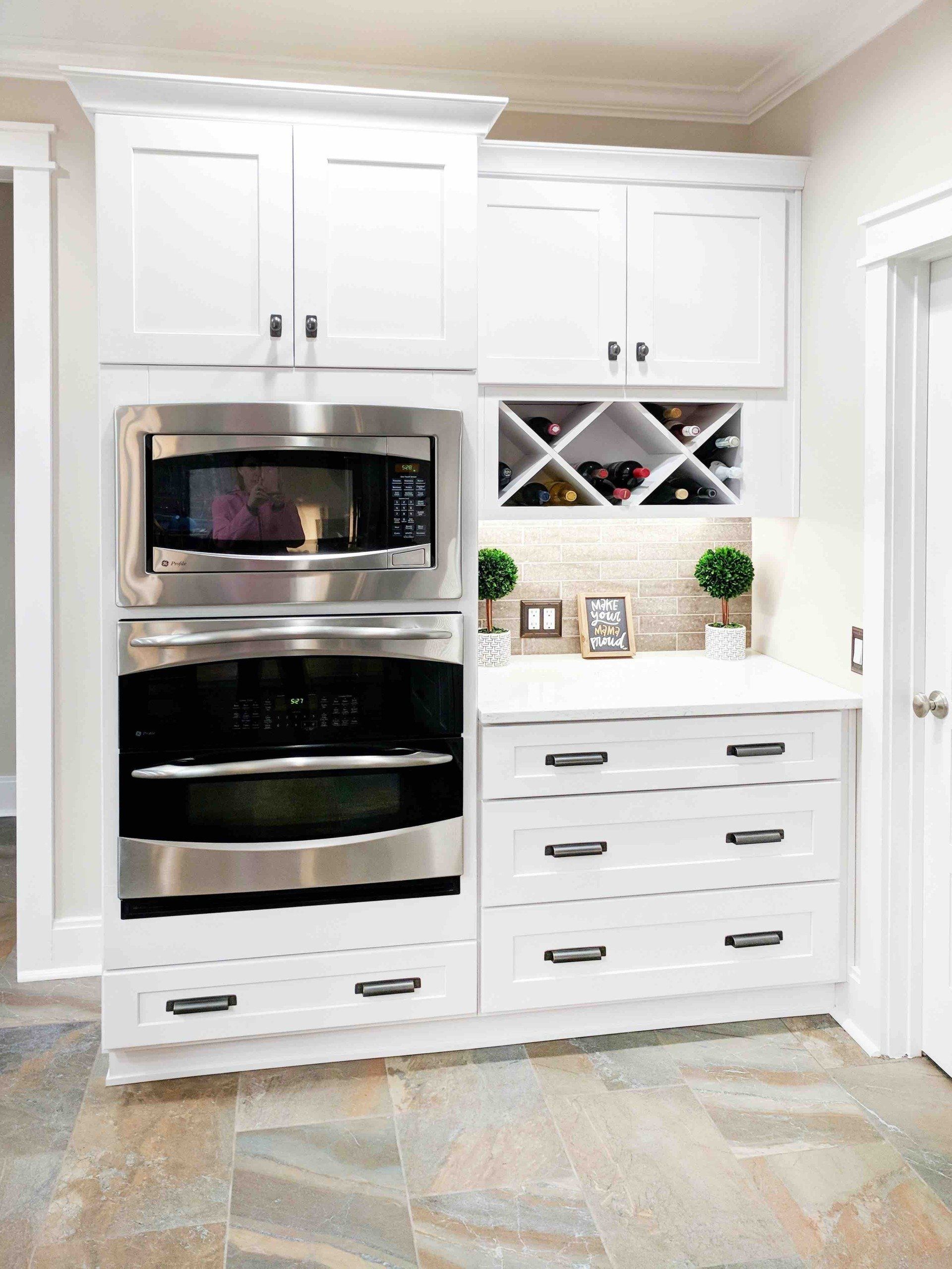A kitchen with stainless steel appliances and white cabinets