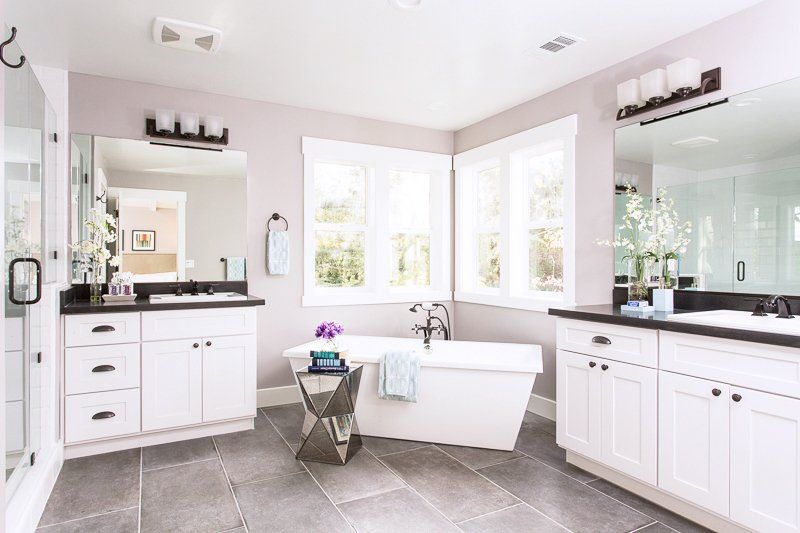 A bathroom with a tub , sinks , and mirrors.