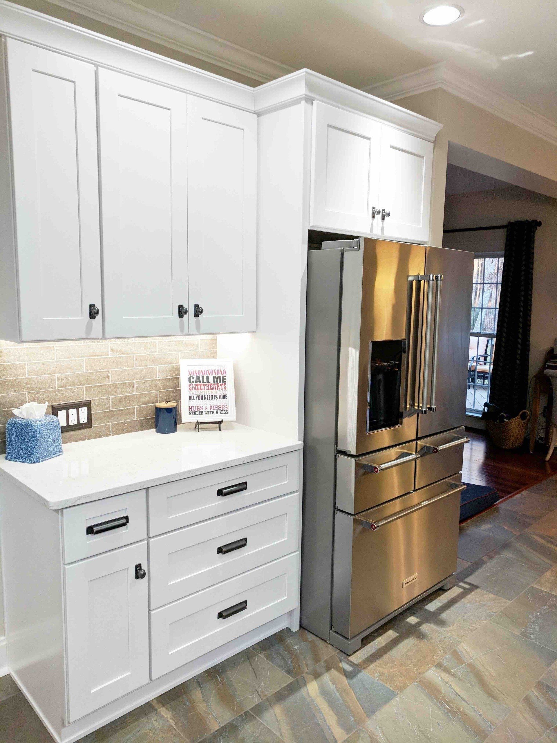 A kitchen with white cabinets and stainless steel appliances.
