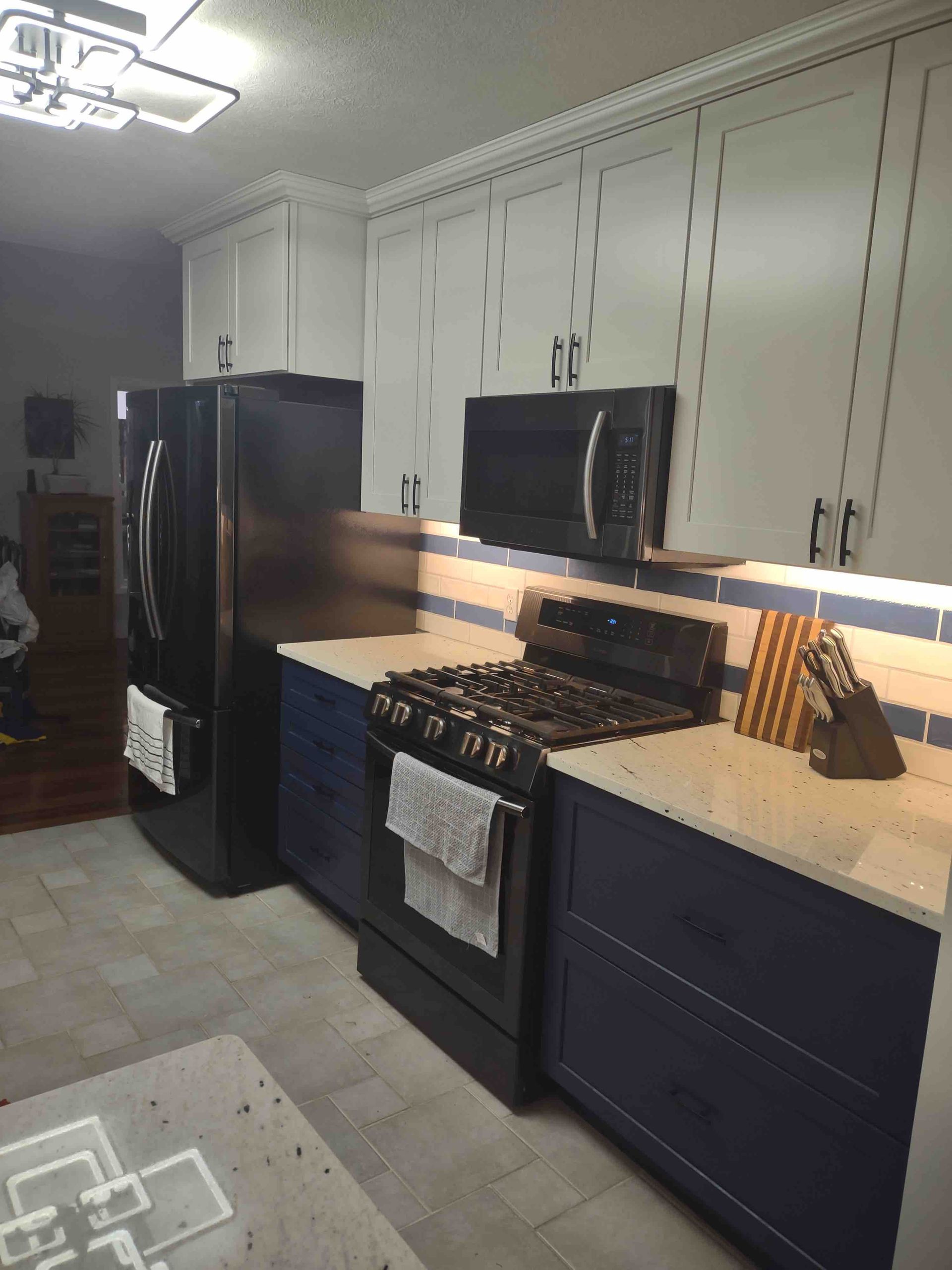 A kitchen with a stove , refrigerator and microwave