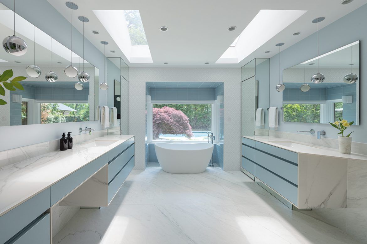 A bathroom with two sinks , a tub and a window.
