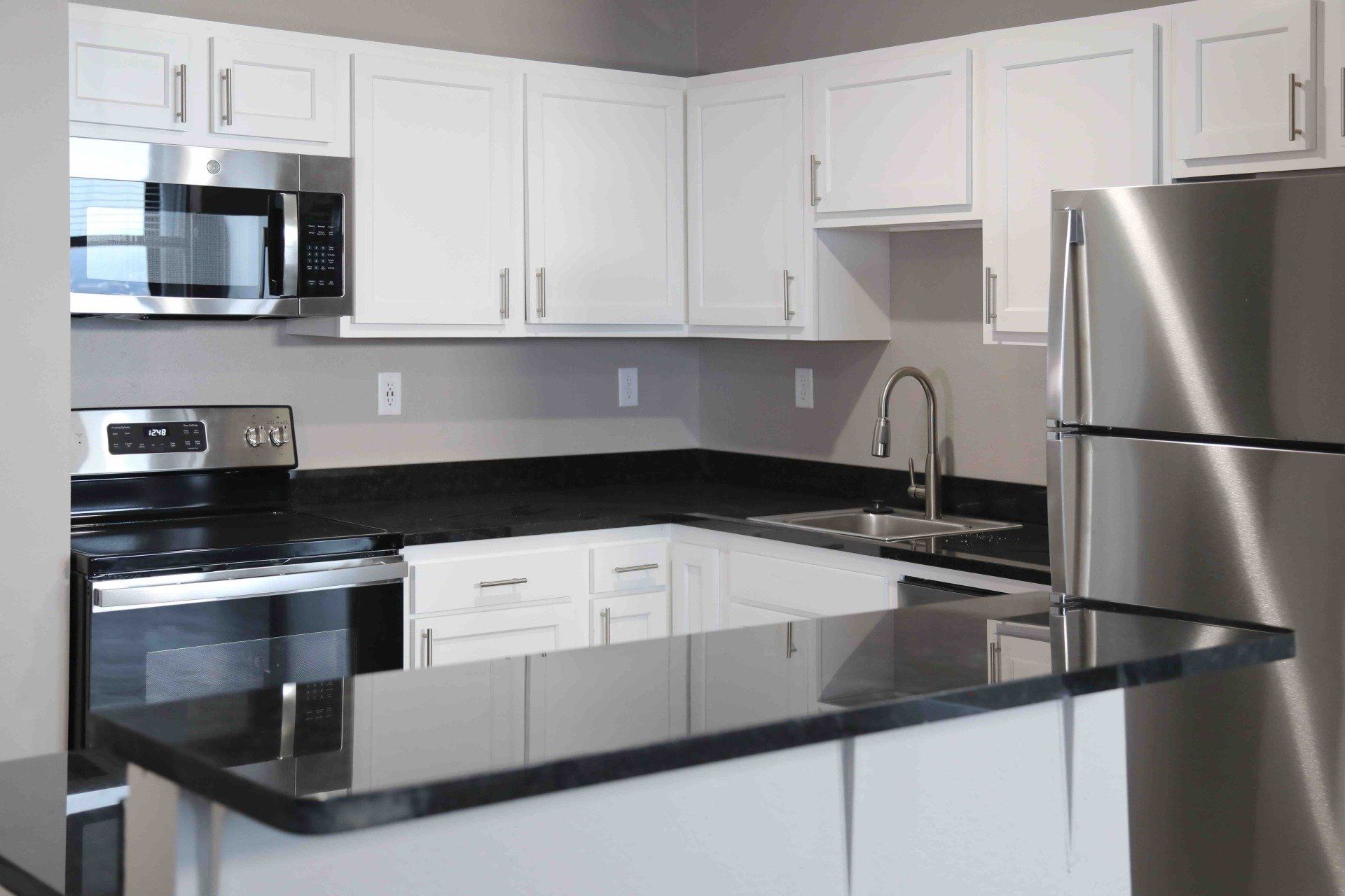 A kitchen with white cabinets and stainless steel appliances