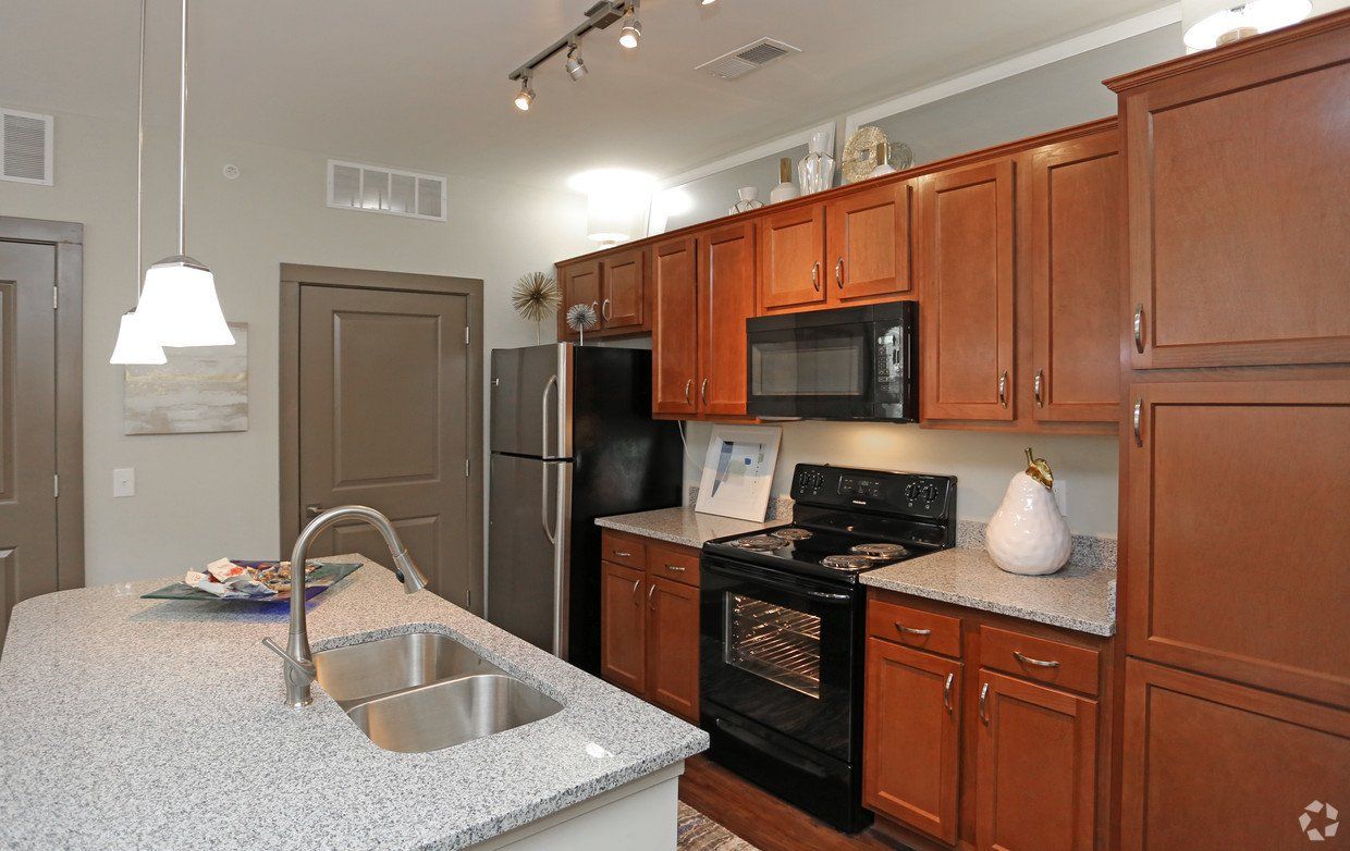 A kitchen with wooden cabinets and granite counter tops