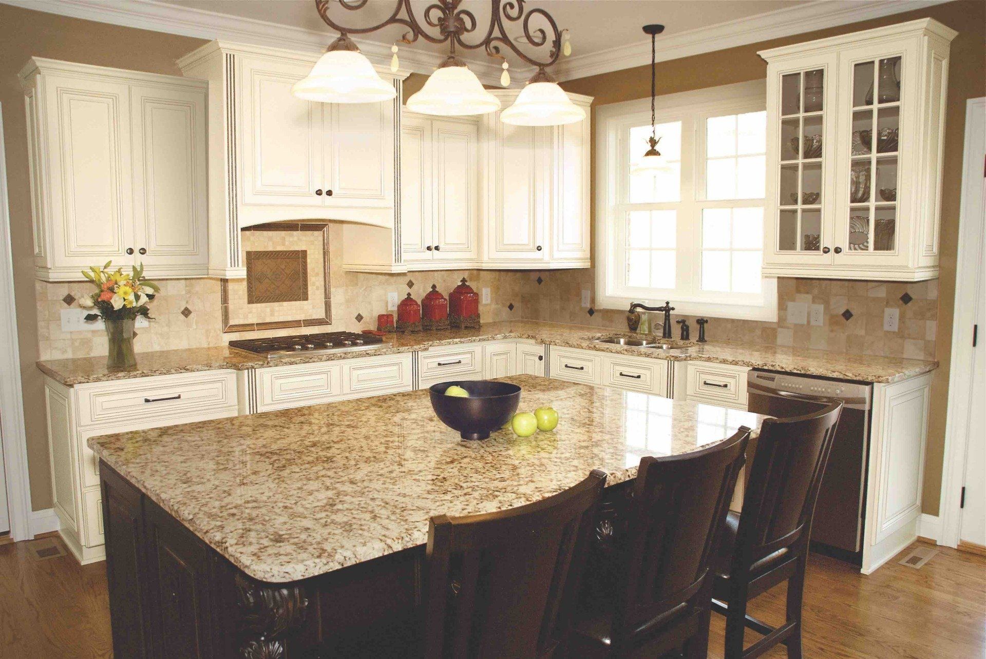 A kitchen with white cabinets and granite counter tops