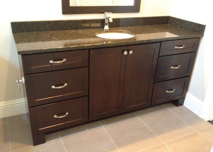 A bathroom vanity with drawers and a sink