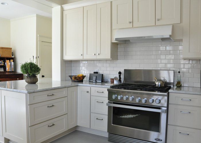 A kitchen with white cabinets and stainless steel appliances