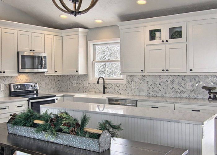 A kitchen with white cabinets and stainless steel appliances