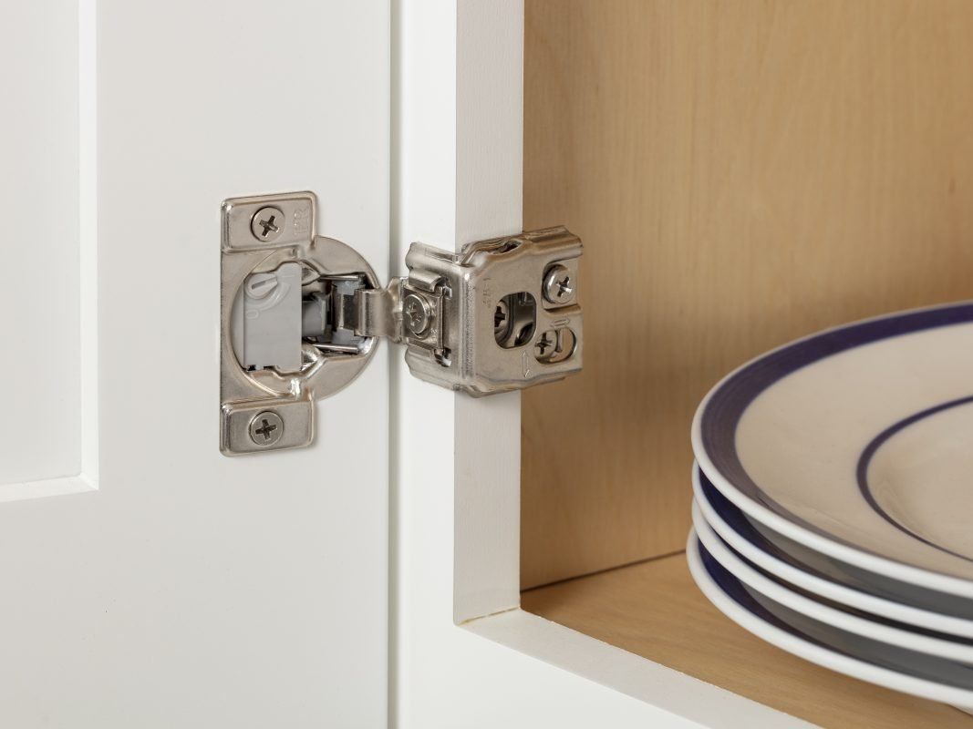 A stack of plates are sitting on a shelf in a cabinet.