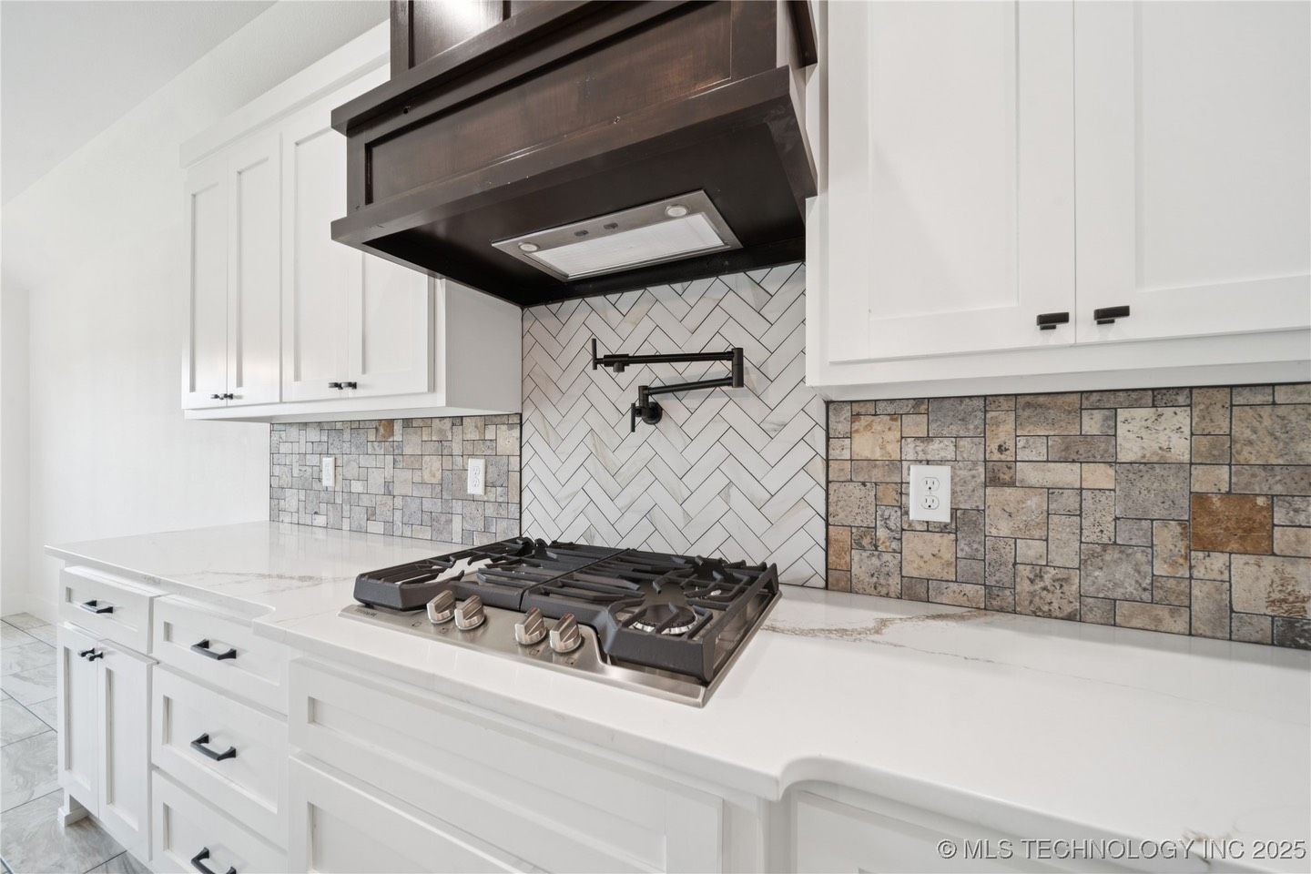 A kitchen with white cabinets and a stove top oven.
