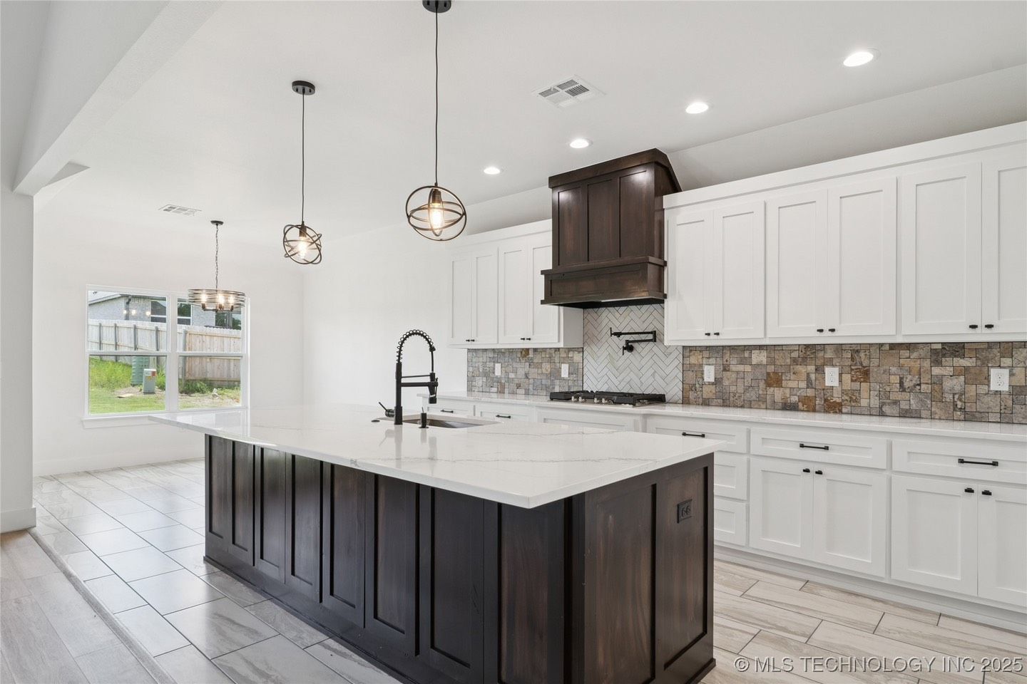 A kitchen with white cabinets and a large island in the middle.