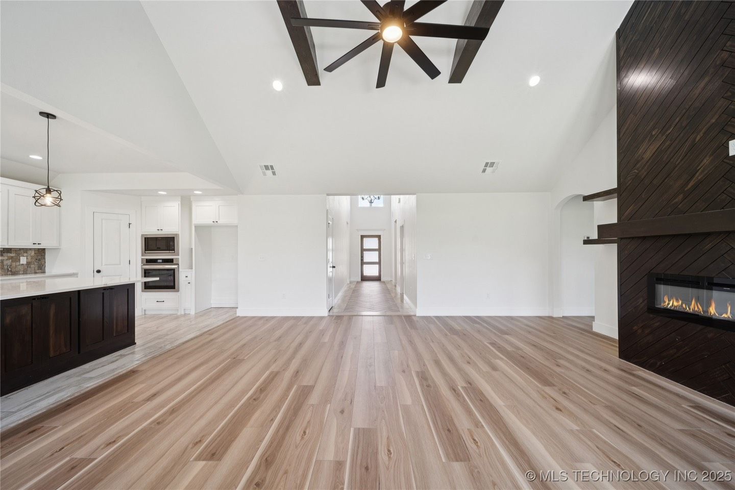 An empty living room with hardwood floors and a fireplace.