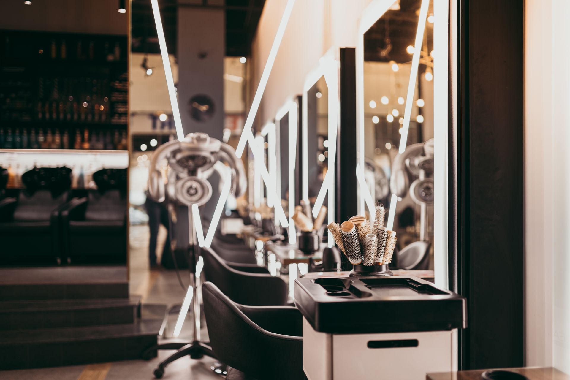 A hair salon with a lot of chairs and a mirror.