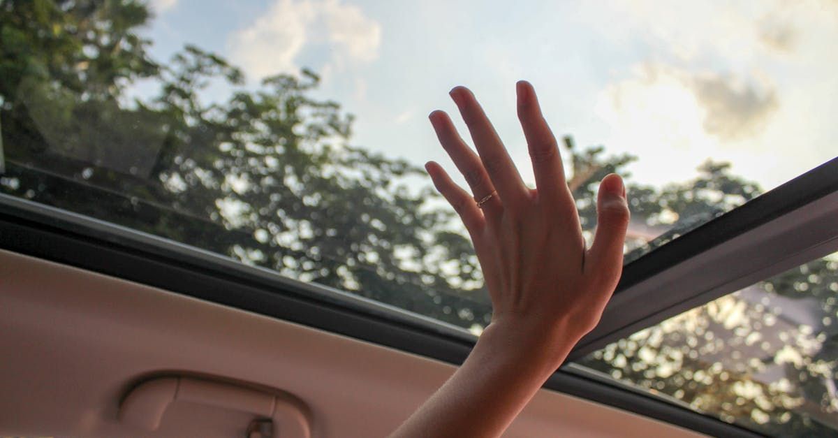 A woman 's hand is reaching out of the sunroof of a car.  | Complete Auto Service Center