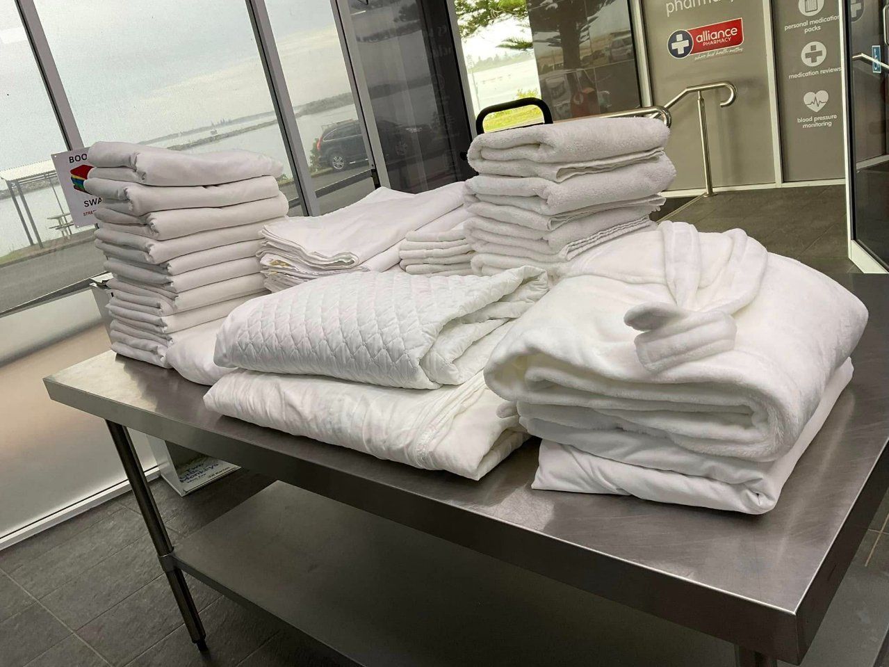A Table with A Lot of White Towels on It — Ezy Laundrette Diamond Beach in Diamond Beach, NSW