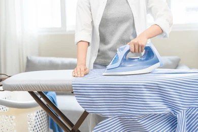 A Person is Ironing a Shirt on a Ironing Board — Ezy Laundrette Diamond Beach in Diamond Beach, NSW
