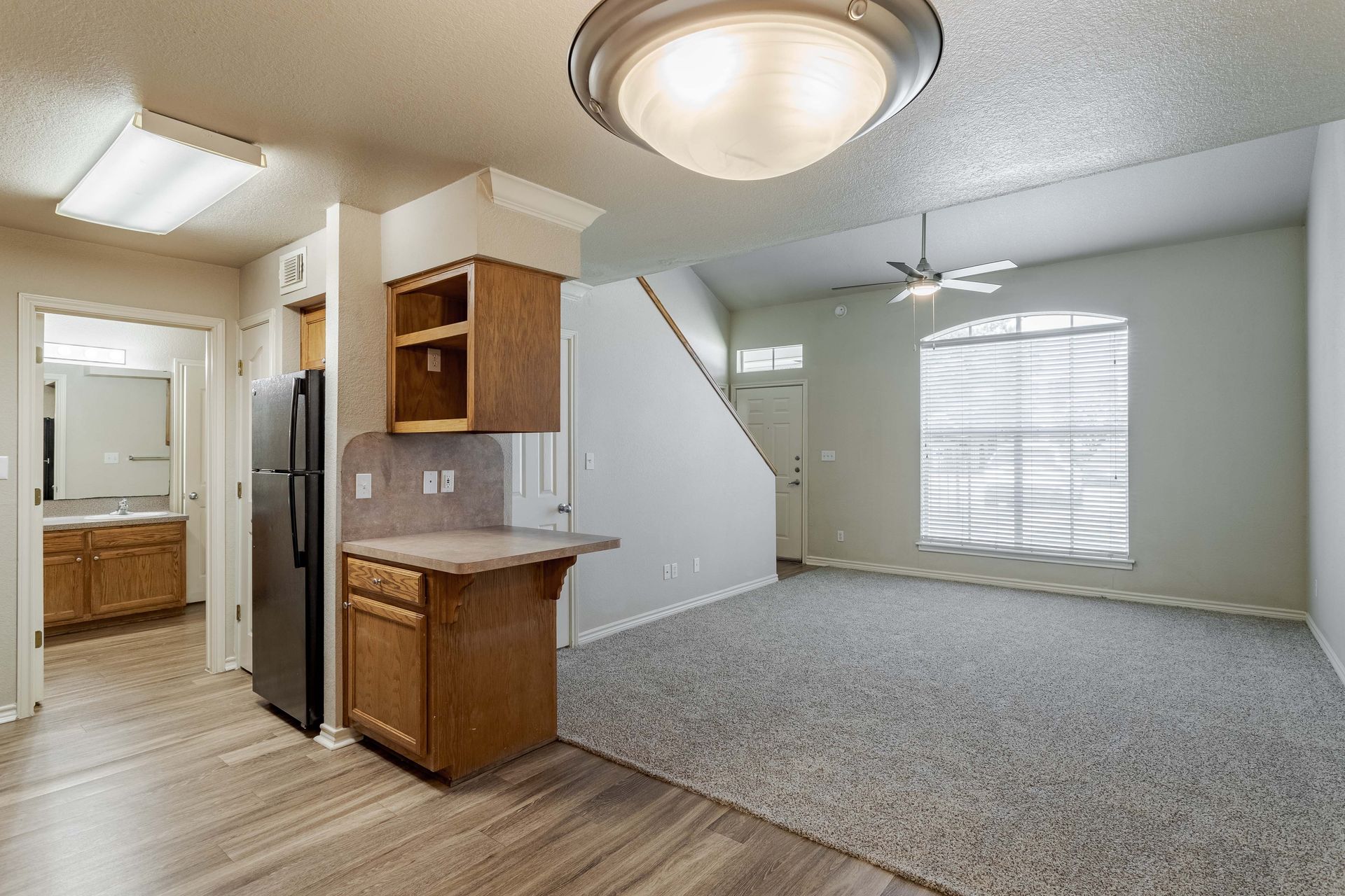An empty room with a ceiling fan and a large window at The Pointe in Beaumont, TX.
