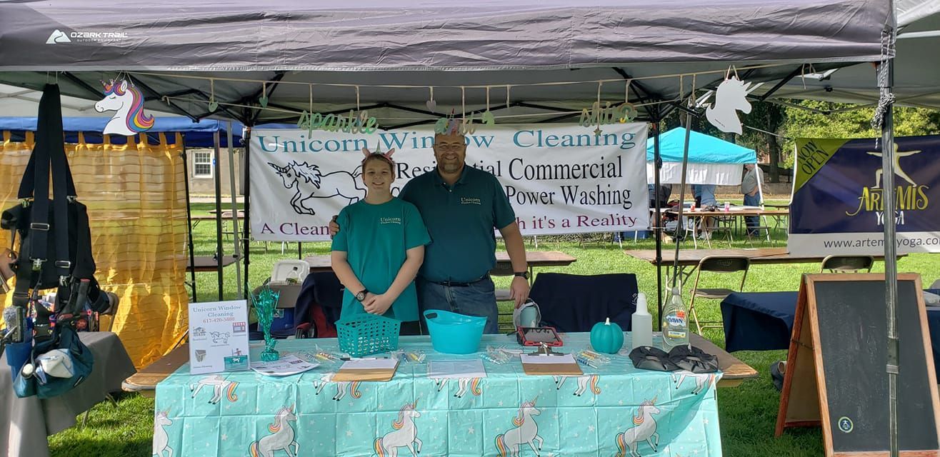 Two men are standing behind a table under a tent.