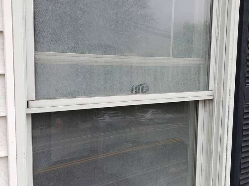 A close up of a window with a reflection of a car in it.