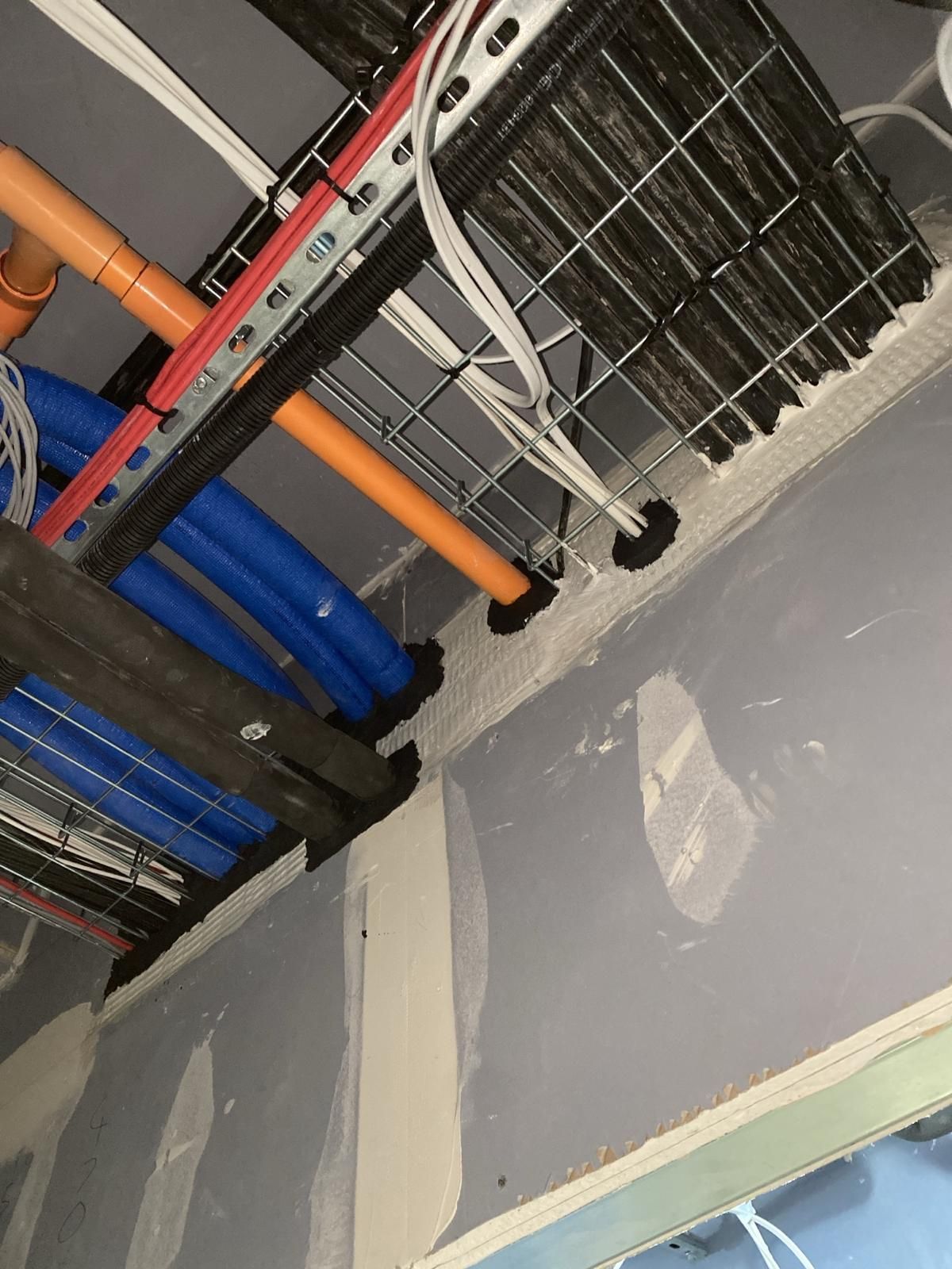 A bunch of pipes are hanging from the ceiling of a building.